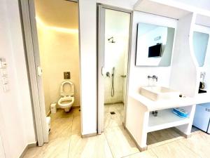 y baño con lavabo, aseo y espejo. en La Villa Rooms en Mykonos ciudad