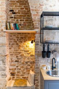 uma cozinha com uma parede de tijolos e um lavatório em Rooms and Apartments Djanovic em Split