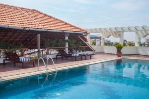 a swimming pool with chairs next to a building at Residency Tower in Trivandrum