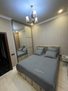 - une chambre avec un grand lit et un miroir dans l'établissement Apartments in the center of Gyumri, à Gyumri