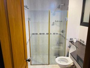 a bathroom with a shower and a toilet at Riviera palms 1 Luxury 1 BHK apartment with Swimmimg Pool view- Arpora - near baga beach in Old Goa