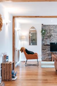 a living room with a chair and a fireplace at The Grain Loft in Clun