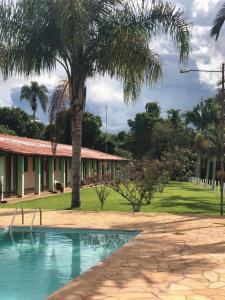 una casa con una palmera y una piscina en Pousada Rancho Caipira en Socorro
