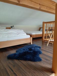a blue rug on the floor in a room with two beds at Apartment mit Terrasse und Garten in Saalfelden am Steinernen Meer