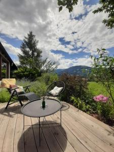 un patio con mesa y sillas en una terraza de madera en Apartment mit Terrasse und Garten, en Saalfelden am Steinernen Meer