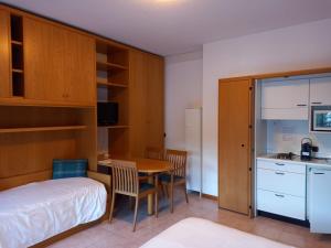 Cet appartement comprend une chambre avec un lit et une table ainsi qu'une cuisine. dans l'établissement Residence Biancaneve, à Aprica