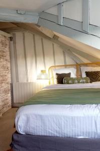 ルーアンにあるGite Les Lanternesのストライプの壁とベッドのある寝室 +10枚の写真