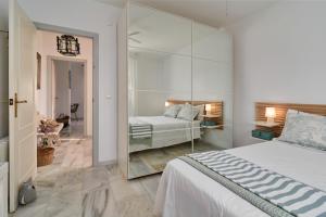 een slaapkamer met een wit bed en een spiegel bij Casa Sueña in Calahonda