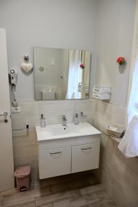 y baño con lavabo blanco y espejo. en La Garampa, en Cesena