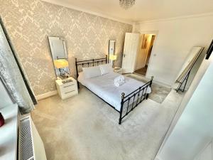 - une chambre avec un lit et un miroir dans l'établissement Glen Fern Lodge - Garden Apartment with Parking - Heart of Town Centre - Close to Beach, à Bournemouth
