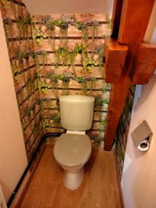 ein WC im Bad mit einer Wand mit Pflanzen in der Unterkunft L'école buissonnière 
