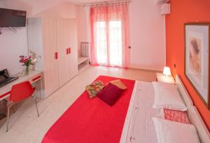 a bedroom with a large bed with a red blanket at B&B Mazzini in Alba Adriatica