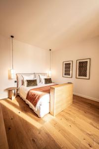 Hôtel Le Mosaïque في ناربون: غرفة نوم بسرير كبير وارضية خشبية