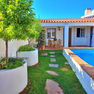 a backyard with a swimming pool and a house at Vila Saraz in Campinho