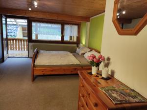ein Schlafzimmer mit einem Bett und einem Tisch mit Blumen darauf in der Unterkunft Geräumige Wohnung im Schwarzwald in Seelbach