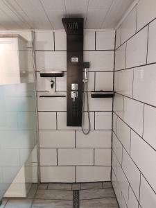 eine Dusche in einem Badezimmer mit weiß gefliesten Wänden in der Unterkunft Geräumige Wohnung im Schwarzwald in Seelbach + 9 Fotos