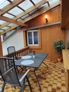 eine Terrasse mit einem Tisch und Stühlen auf einem Holzboden in der Unterkunft Geräumige Wohnung im Schwarzwald in Seelbach