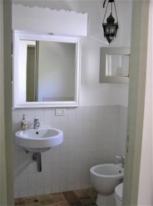 a bathroom with a sink and a toilet and a mirror at Villa Il Melograno in Leni