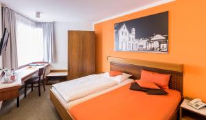 a hotel room with a bed and a desk and a desk at Fischer's Hotel Brauhaus 24h Self Check In in Mössingen +36 photos