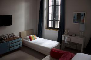 a small bedroom with a bed and a window at Hôtel Absolu in Castelsarrasin