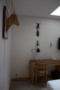 Habitación con escritorio y una araña en la pared en Hôtel Absolu, en Castelsarrasin