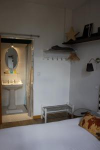1 dormitorio con lavabo, espejo y cama en Hôtel Absolu, en Castelsarrasin