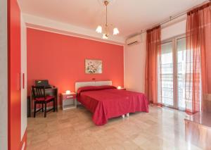 a red bedroom with a bed and a desk at B&B Mazzini in Alba Adriatica