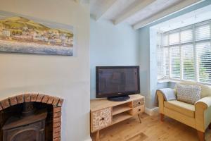 a living room with a tv and a fireplace at Host & Stay - Honey Cottage in Hinderwell