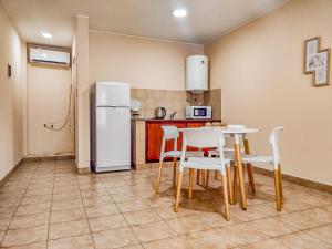 eine Küche mit einem Tisch und Stühlen sowie einem Kühlschrank in der Unterkunft Departamentos Zegada - Cocina completa - Dos cuadras del centro - Todo Nuevo in San Salvador de Jujuy