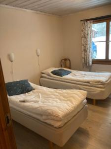 3 Betten in einem Zimmer mit Fenster in der Unterkunft Furudals Bruk in Furudals Bruk