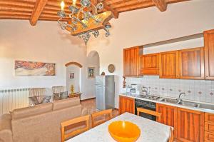 a kitchen with wooden cabinets and a table in a kitchen at Agriturismo Fattoria il Piano - Casa Bugno - San Gimignano in San Gimignano