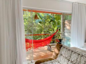 um quarto com uma janela com uma rede de descanso num alpendre em Vários Apartamentos no villas maceio em Maceió