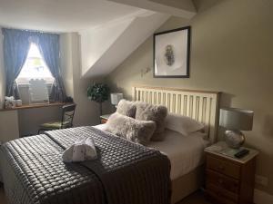 1 dormitorio con cama con almohadas y ventana en Hillsdale B&B in Ambleside en Ambleside