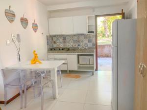 a kitchen with a white table and a refrigerator at Vários Apartamentos no villas maceio in Maceió