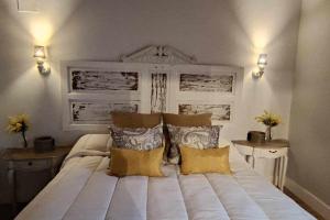 sypialnia z dużym białym łóżkiem z poduszkami w obiekcie Precioso Apartamento 2 Hab con Bañera Hidromasaje w mieście O Barco de Valdeorras