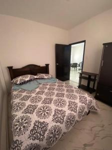 a bedroom with a bed with a black and white comforter at Apartamento 920 San Gil in San Gil