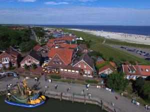 a boat in the water in front of a beach at Janssens Hotel in Neuharlingersiel