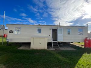 a mobile home is parked in a yard at Eagle 4a, Scratby - California Cliffs, Parkdean, sleeps 8, bed linen and towels included, pet friendly and close to the beach in Great Yarmouth
