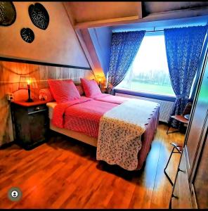una camera con un grande letto e una finestra di Bed & Breakfast Prins Hendrik (Zuidschermer) a Zuidschermer