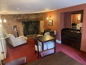 ein Wohnzimmer mit einem Tisch und einem Kamin in der Unterkunft Myrtle Cottage B&B in Porlock