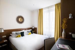 a bedroom with a large white bed and a window at Hôtel Le Colisée in Paris