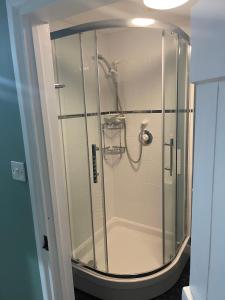 a shower with a glass door in a bathroom at Myrtle Cottage B&B in Porlock