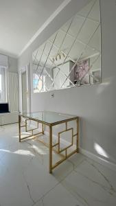 a white room with a table and a mirror at Glamour Apartment przy plaży, z parkingiem prywatnym in Sopot