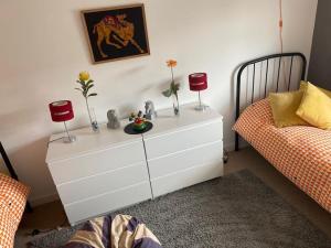 ヘイスティングスにあるShoreline Coastal Get Awayのベッドルーム1室(赤いキャンドル2本付きの白いドレッサー付)