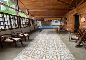 a large room with a ping pong table and chairs at Casa acolhedora com lazer e espaço gourmet in Petrópolis