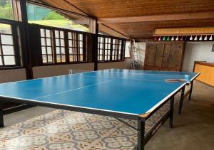 uma mesa de pingue-pongue azul num quarto em Casa acolhedora com lazer e espaço gourmet em Petrópolis