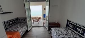 1 dormitorio con 2 camas y puerta a un balcón en Marina Holiday Home, en Pizzo