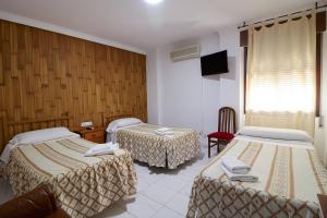 Postel nebo postele na pokoji v ubytování Hotel Virgen de los Reyes