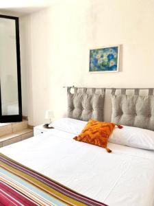 uma grande cama branca com um cobertor laranja em Casa Max - a 60 passi dal mare em San Foca