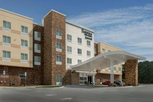 Fairfield Inn & Suites by Marriott Washington في واشنطن: مبنى الفندق وامامه موقف سيارات
